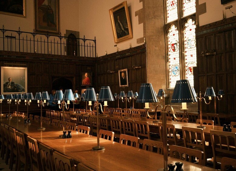A library with wooden tables, blue lamps, and stained glass windows. 4