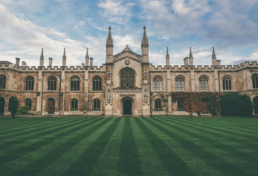 A historic building with a symmetrical facade, tall spires, and a central clock tower. 2