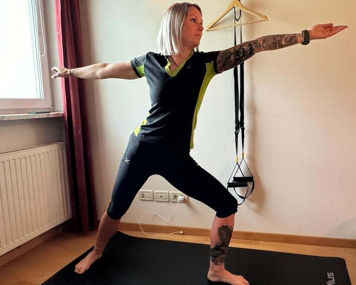 A person in a yoga pose on a mat with a resistance band in the background. 4