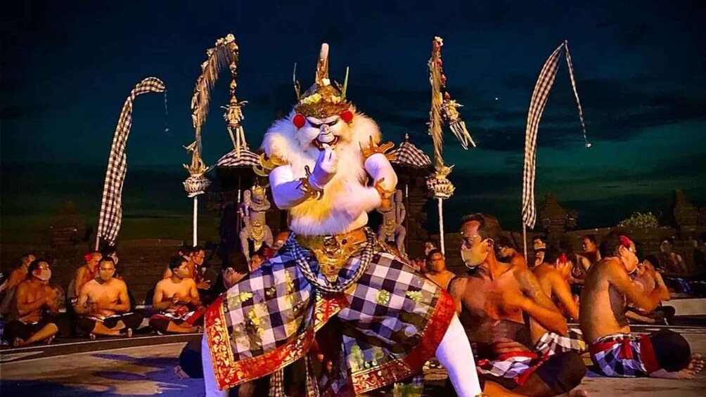 A performer in traditional attire with a headdress, surrounded by onlookers. 1