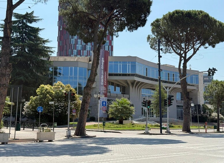 A modern building with a unique architectural design, surrounded by trees and a pedestrian area. 3