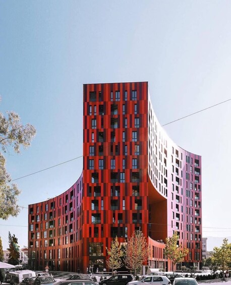 A modern red building with a curved facade and multiple windows. 4