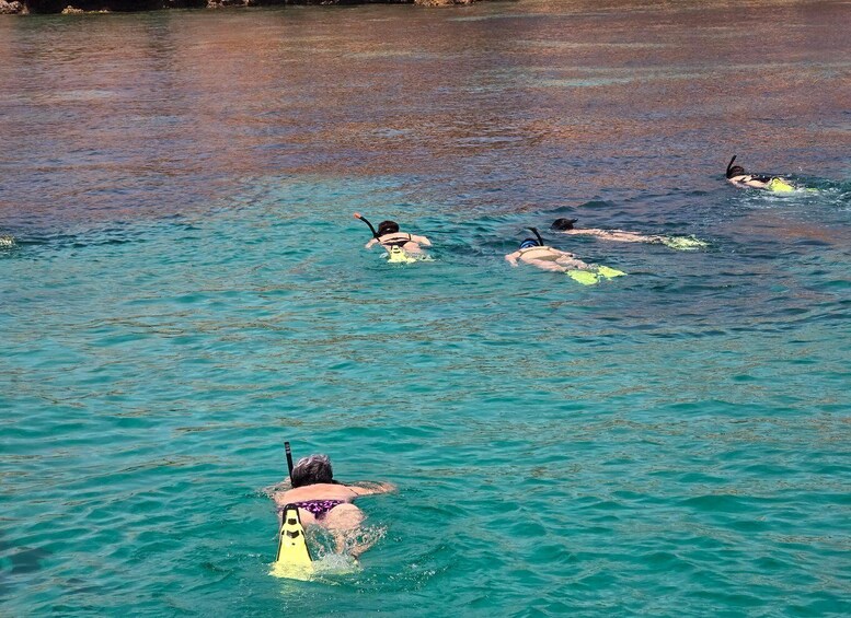People snorkeling in clear turquoise water. 2