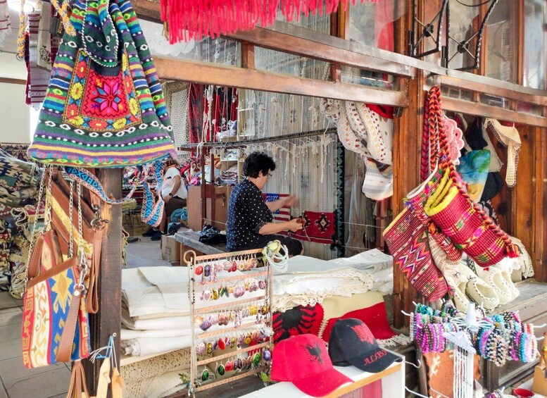 A market stall with colorful textiles and bags. 5