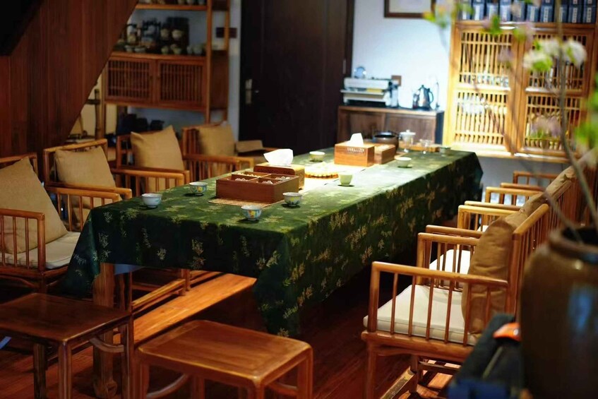 A traditional Japanese room with tatami mats, wooden furniture, and a green tablecloth. 5