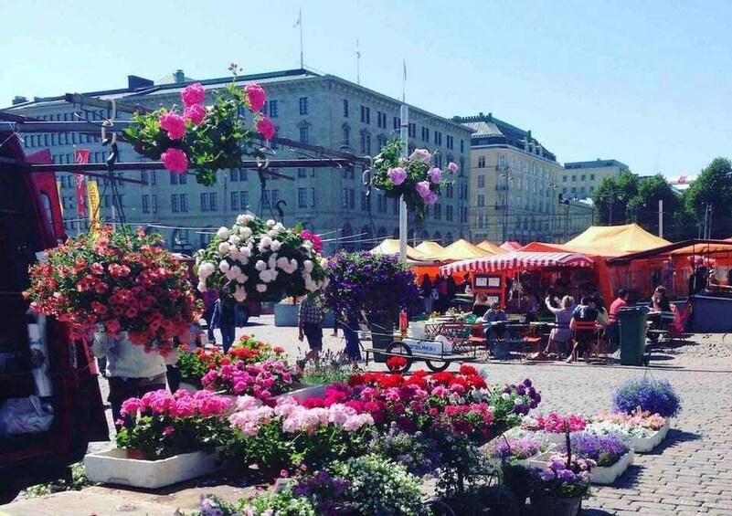 A flower market with various colorful flowers and a building in the background. 4