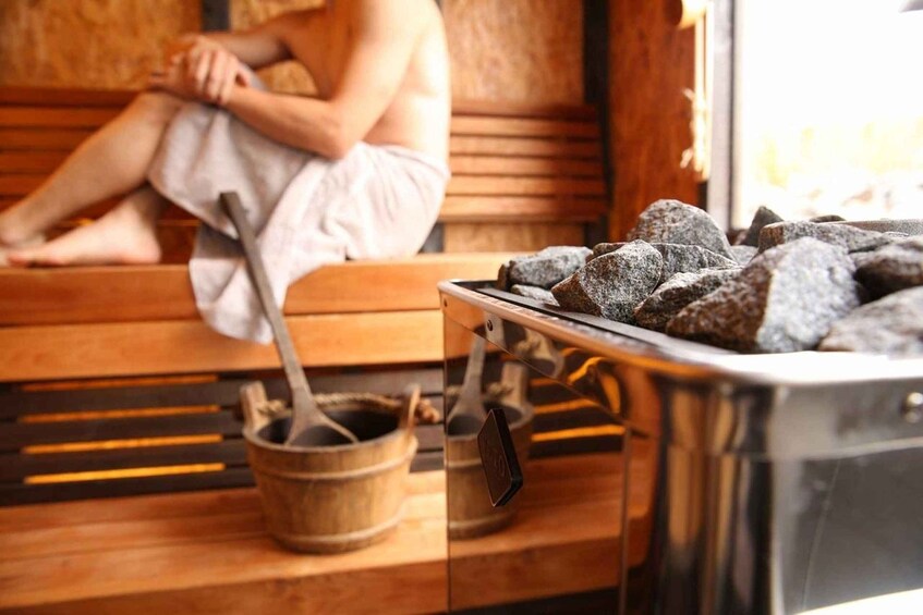 A sauna with wooden benches and a stone heating element. 5