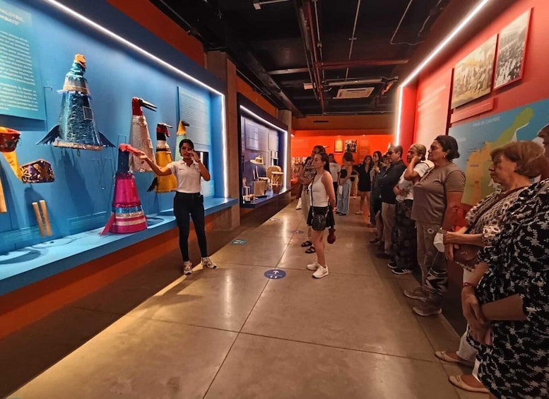 A museum corridor with exhibits on the left and a group of visitors on the right. 5