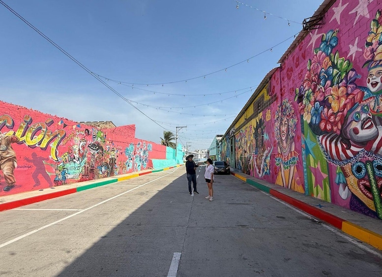 A street with colorful murals on the walls and a clear sky. 4