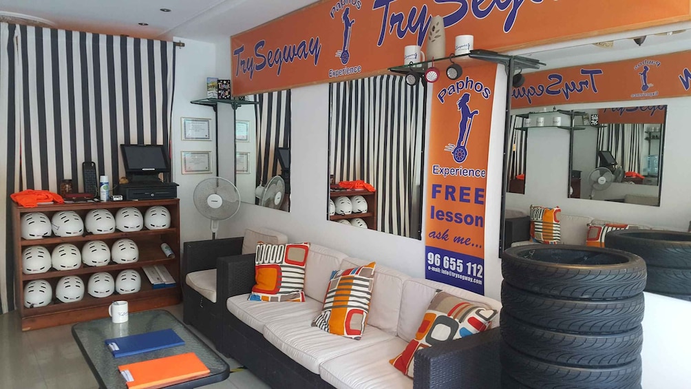 A room with a white sofa, striped pillows, and a sign offering free lessons. 4