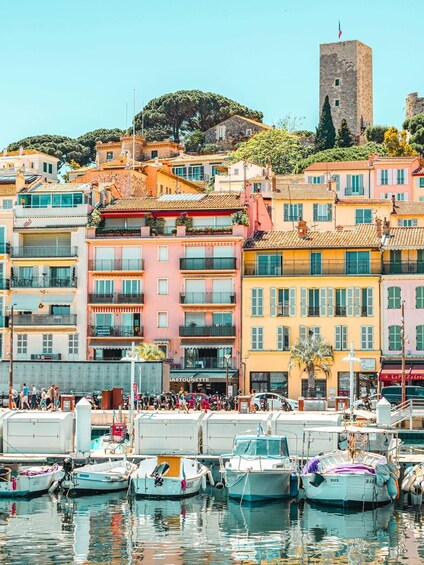 Colorful buildings, a tower, and boats docked at a harbor. 4