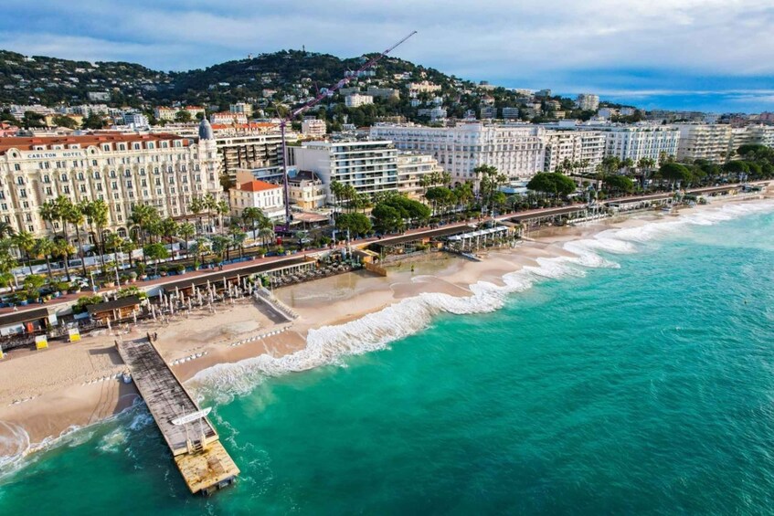 A coastal cityscape with a beach, a pier, and a hotel named Carlton Hotel. 2