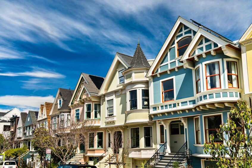 A row of Victorian-style houses with bay windows and a clear blue sky. 4