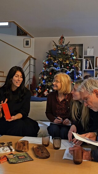 Four people sitting around a table with a decorated Christmas tree in the background. 1