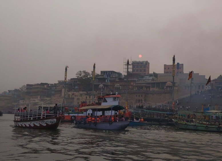 A river with boats, a cityscape with buildings, and a sun in the sky. 2