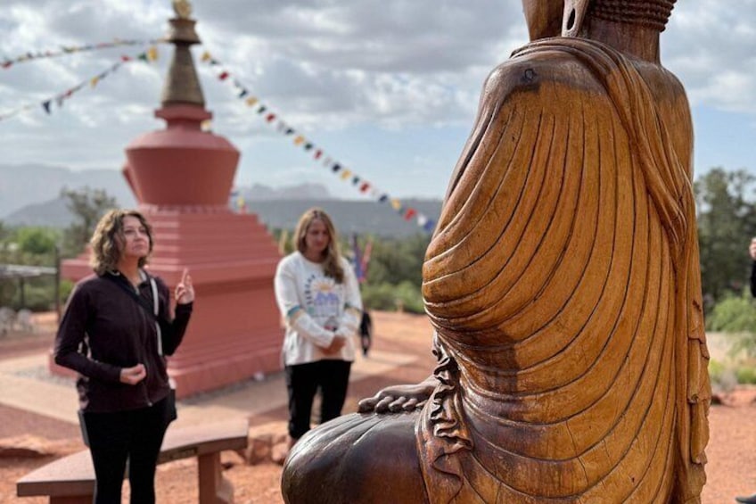 A large wooden statue with a red pagoda in the background. 4