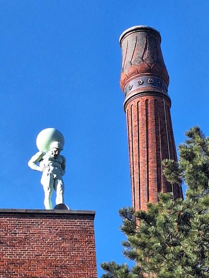 A statue on a building roof and a tall brick chimney. 4