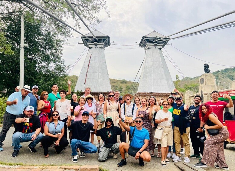 A group of people posing in front of a monument with two large conical structures. 2
