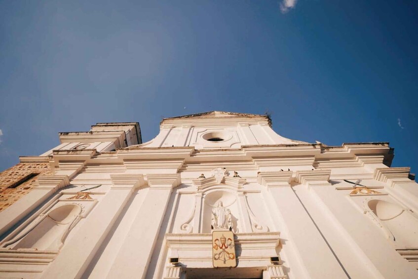 A white building with classical architecture, including columns and a central dome. 3
