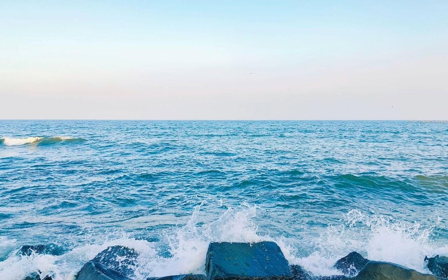A calm sea with waves crashing against rocks. 5