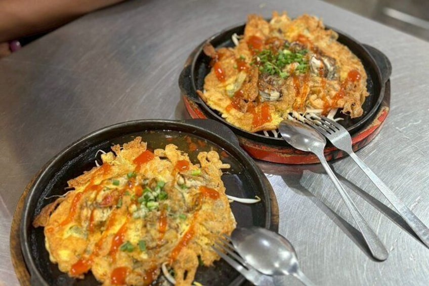 Two bowls of fried egg and vegetable dish on a metal table. 2