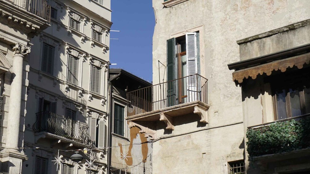 A building with classical architecture, featuring ornate balconies and shutters. 2