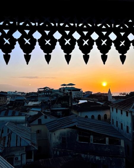 A sunset over a cityscape with traditional buildings and a prominent tower. 3
