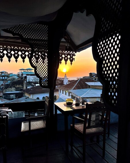 A balcony with a view of a sunset over a cityscape. 1