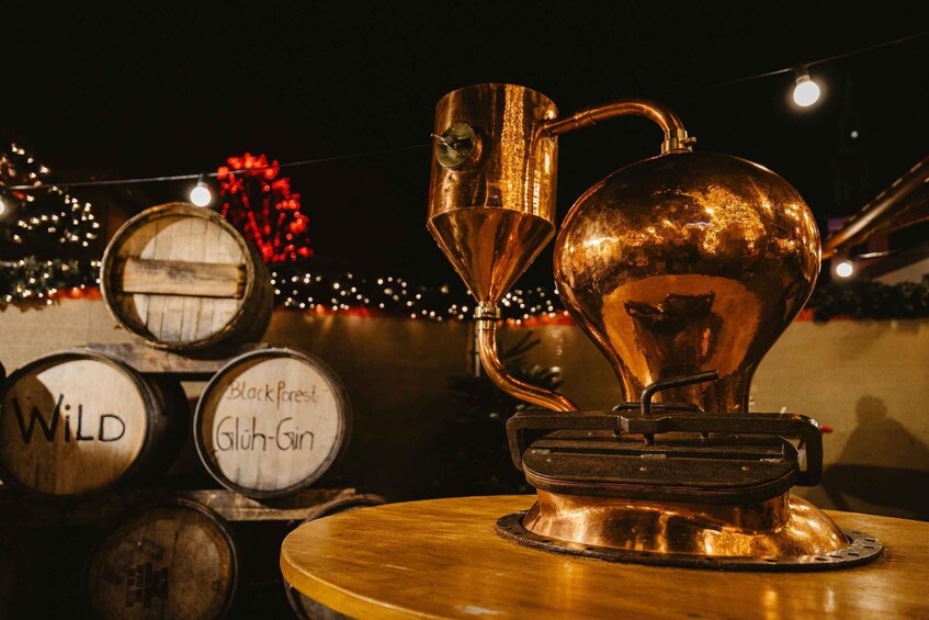 A copper still and wooden barrels with labels like 'Wild' and 'Black Forest' in a dimly lit setting. 3
