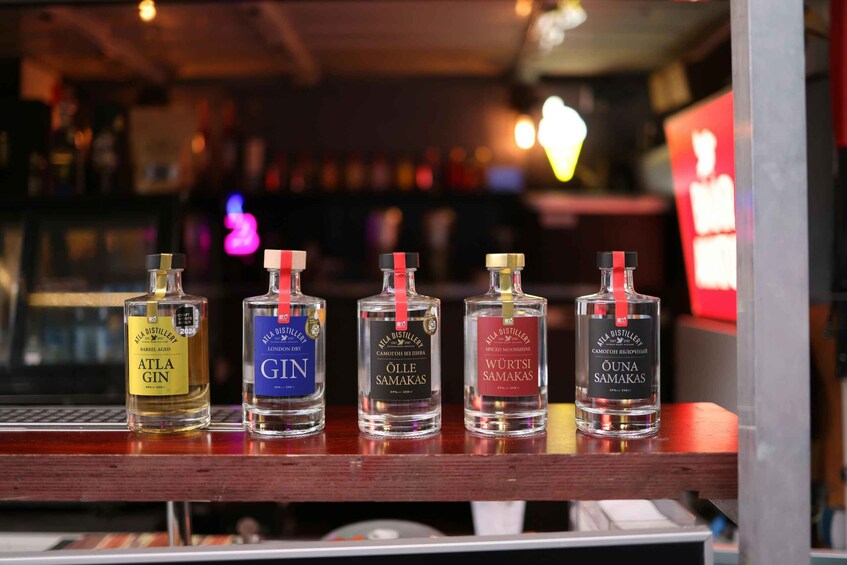 Five bottles of gin on a bar counter. 2