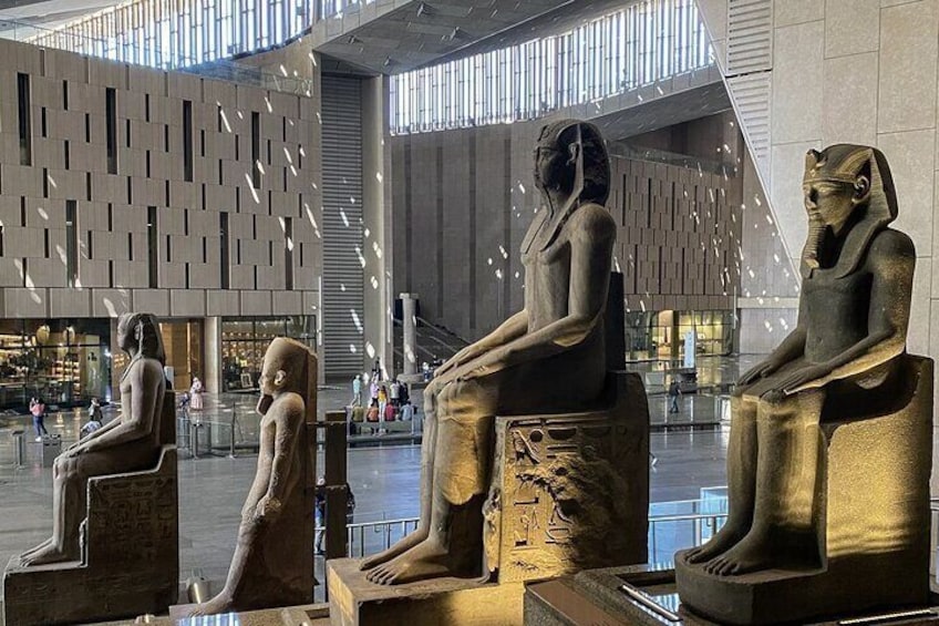 A modern building interior with large golden statues of Egyptian figures. 4