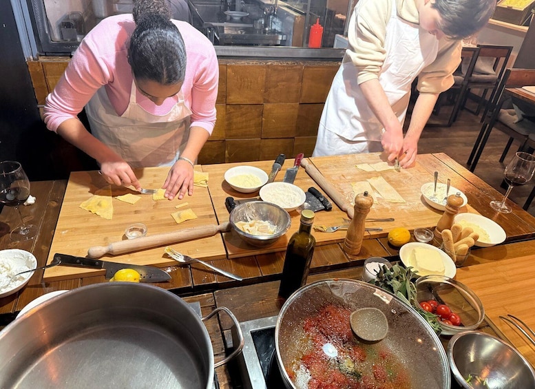 Deux personnes préparent un repas, avec les ingrédients et les ustensiles de cuisine disposés sur une table en bois. 5