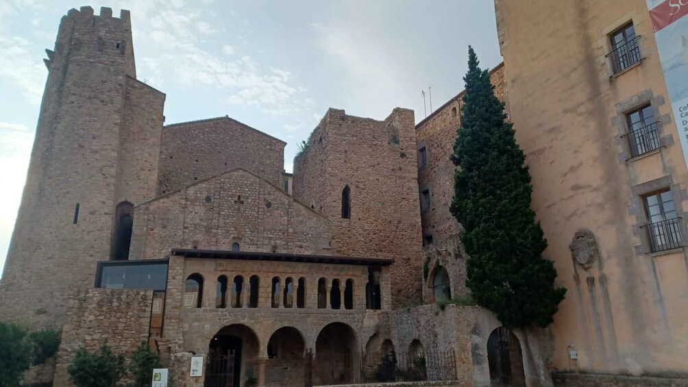 A historic stone building with arched windows and a tall tower. 2