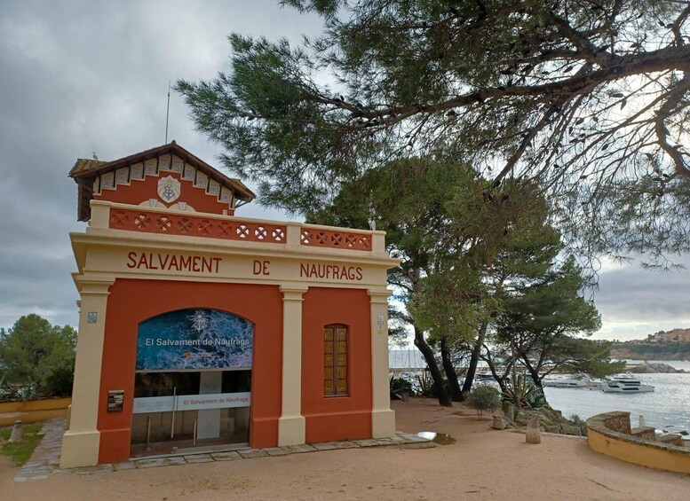 A building with 'SALVAMENT DE NAUFRAGS' signage, a coastal view, and a body of water. 4