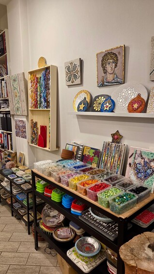 A craft store with mosaic tiles, beads, and decorative items on shelves and tables. 3