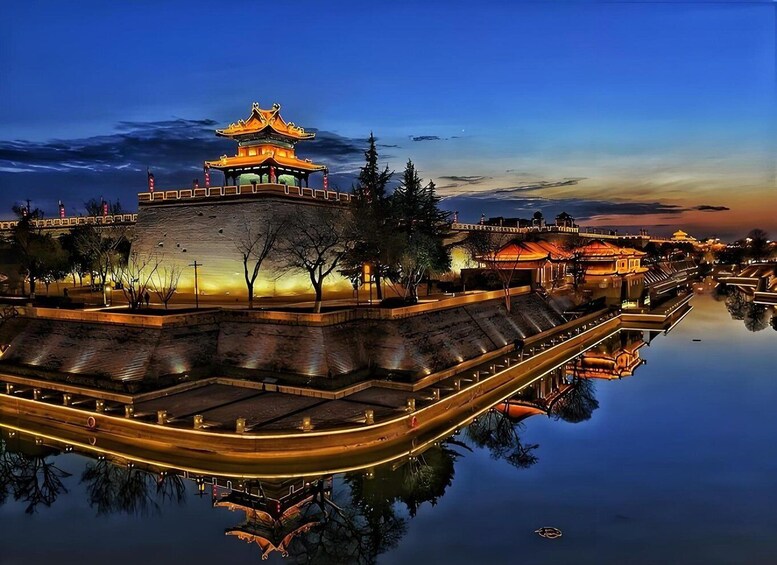 A traditional Chinese pagoda with a reflection in the water, surrounded by a stone wall and trees. 1