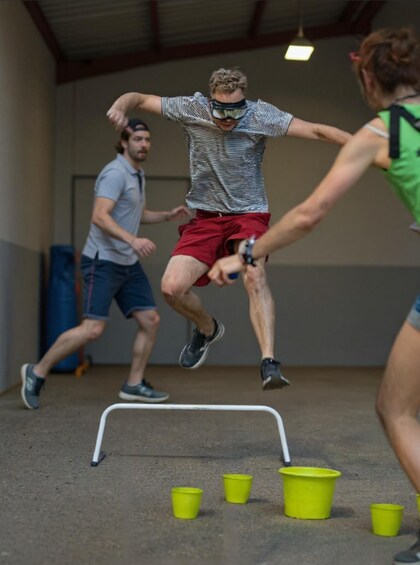 People jumping over hurdles in an indoor training facility. 2