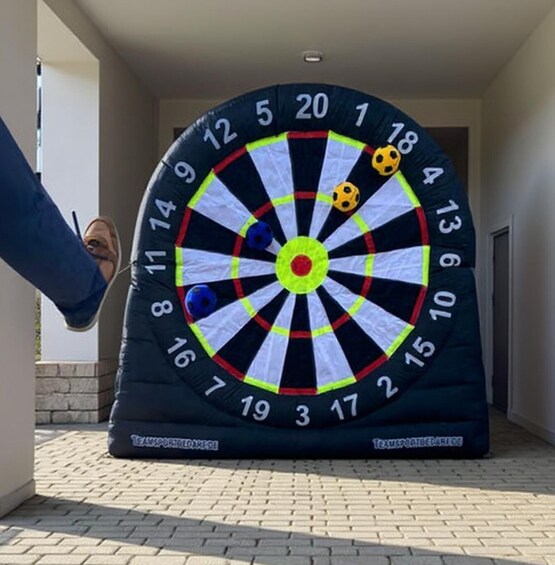 A large dartboard with numbers and colored darts. 3