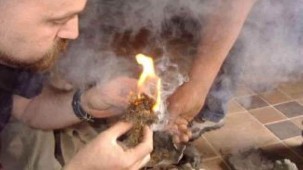 A person holding a lit matchstick. 3