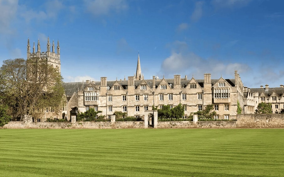 A historic building with multiple towers and a central spire, surrounded by a well-maintained lawn. 2