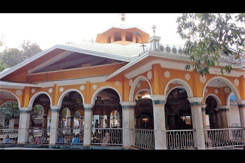A building with a yellow facade, multiple arches, and a covered walkway. 5