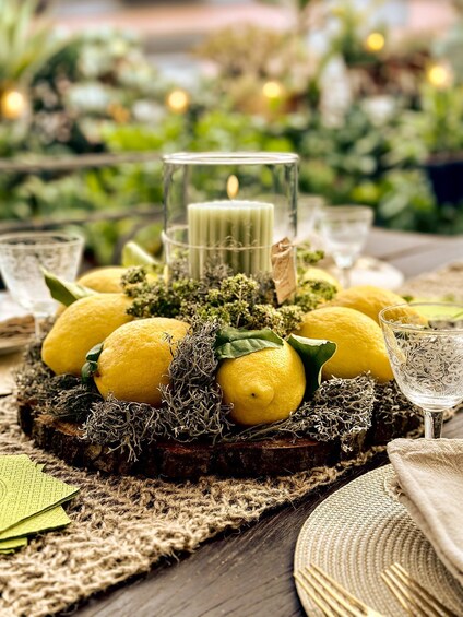 A table setting with lemons, a candle, and decorative greenery. 1