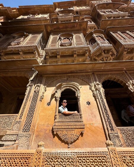 A person inside a carved architectural structure with intricate designs. 5
