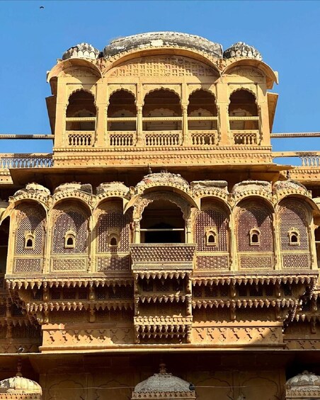 A historic building with intricate carvings and multiple balconies. 4