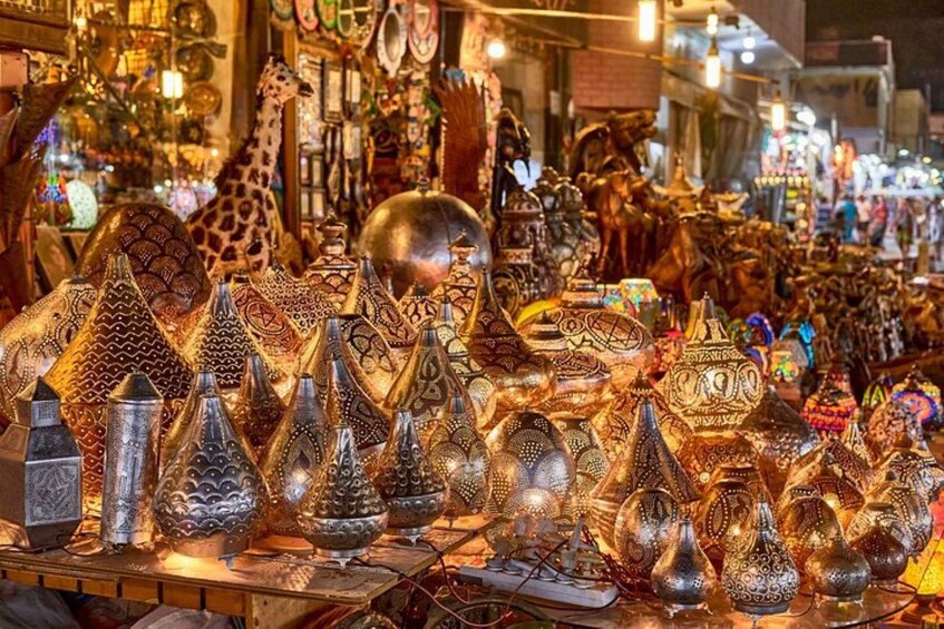 A variety of intricately designed metalware, including vases and bowls, displayed at a market stall. 4