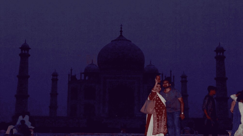 Le Taj Mahal, avec ses quatre minarets et son dôme, est entouré de monde. 2