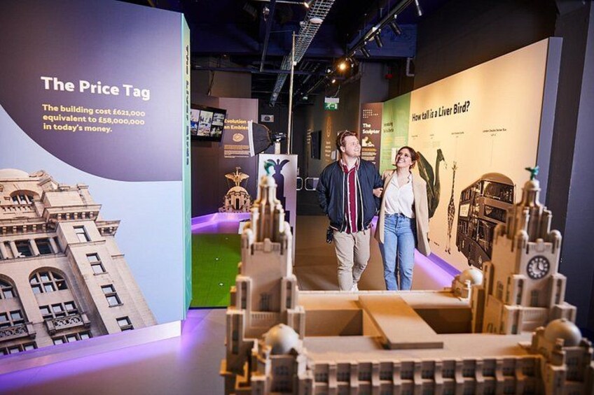 A museum exhibit with a large price tag and a model of a building. 2