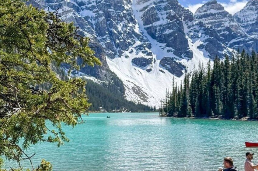 A lake surrounded by snow-capped mountains and dense forest. 1