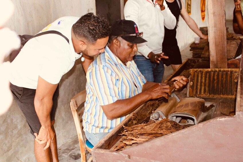 A person working with a large wooden tool, possibly for crafting or processing materials, in a workshop setting. 5
