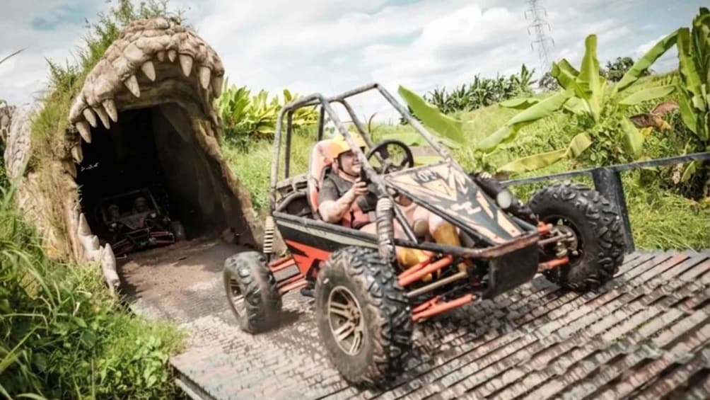 A toy car driving through a tunnel with a dinosaur mouth. 4